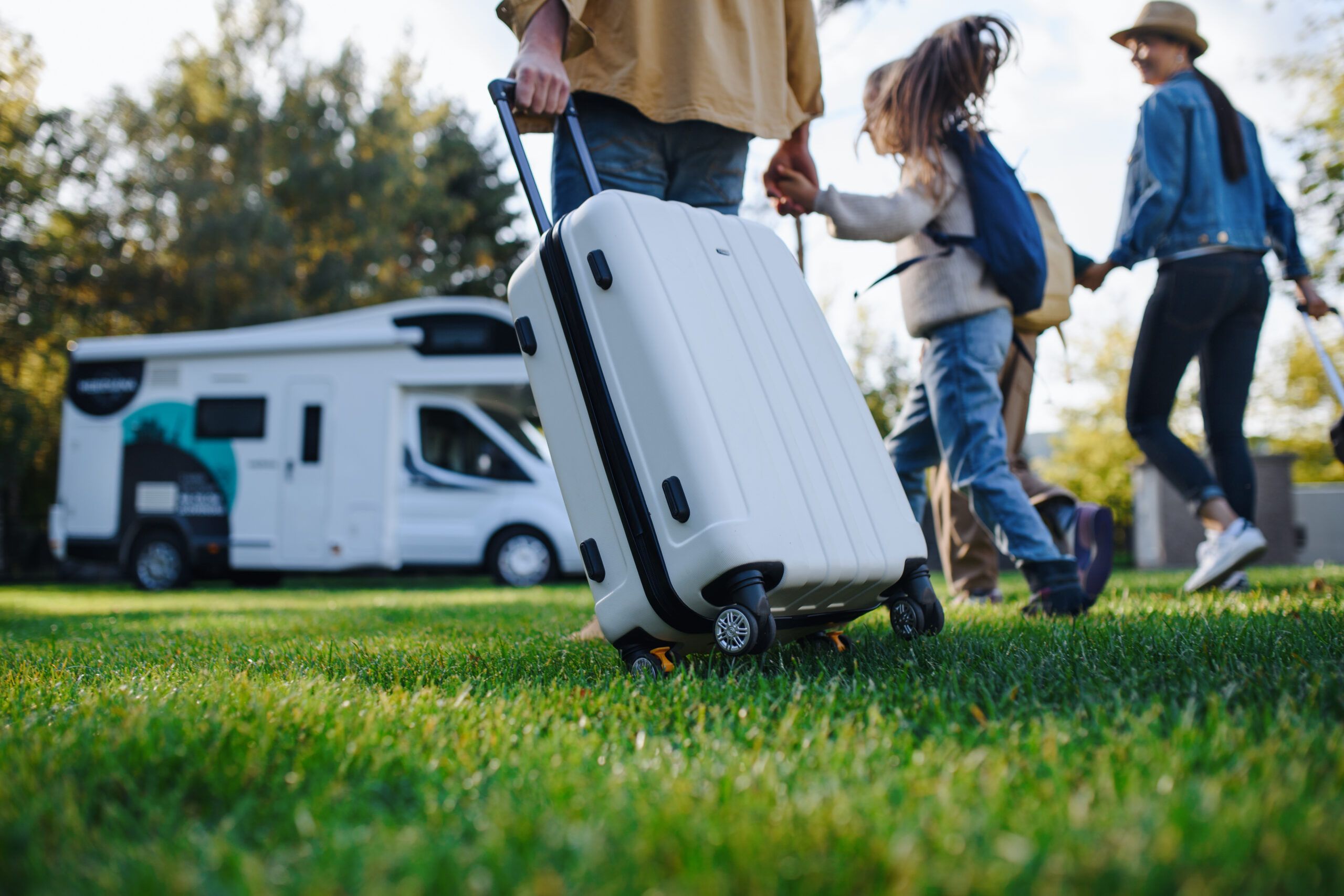 Family carrying suitcases to the motorhome